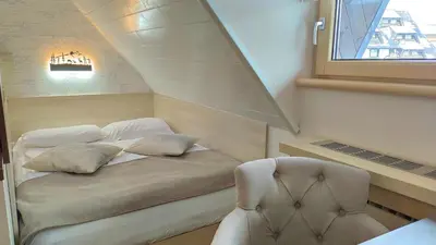 a small bedroom with a bed and a chair at Angella KOP Konaci in Kopaonik