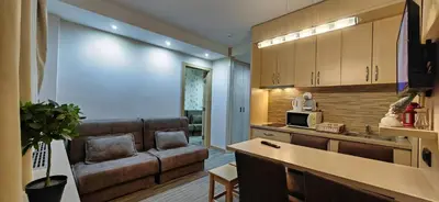 a living room with a couch and a kitchen at Angella KOP Konaci in Kopaonik