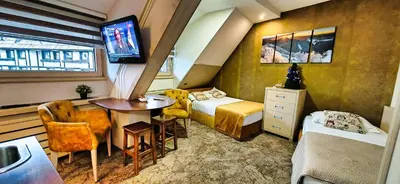 a small room with a bed and a table and a tv at Angella KOP Konaci in Kopaonik
