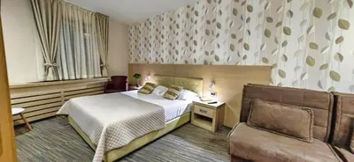 a hotel room with a bed and a couch at Angella KOP Konaci in Kopaonik