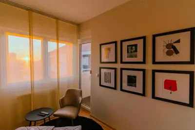 a room with a chair and pictures on the wall at NAR Royalton Accommodation in Niš