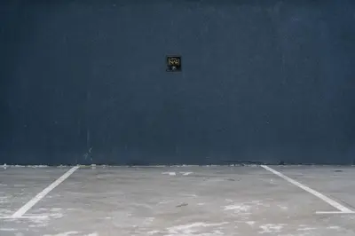 an empty tennis court with a sign on the wall at NAR Royalton Accommodation in Niš