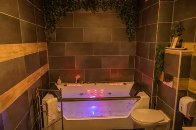 a bathroom with a tub with lights in it at NAR Royalton Accommodation in Niš