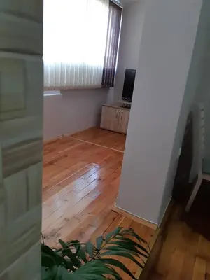 a living room with a wooden floor and a window at Stankovic Apartman in Vranje