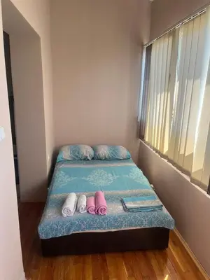 a small bed with two pairs of shoes on it at Stankovic Apartman in Vranje