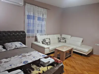 a living room with a couch and a bed at Stankovic Apartman in Vranje