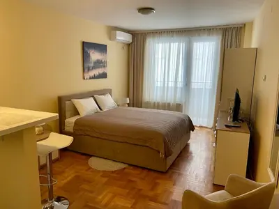 a bedroom with a bed and a television in it at Trident Apartments 2 in Niš