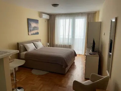a bedroom with a bed and a television in it at Trident Apartments 2 in Niš