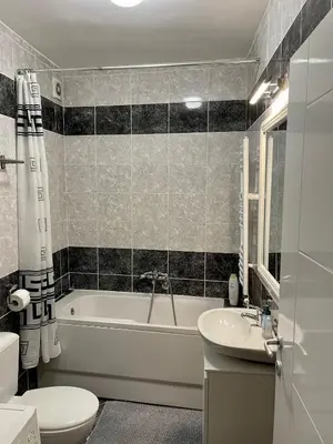 a bathroom with a tub and a toilet and a sink at Trident Apartments 2 in Niš