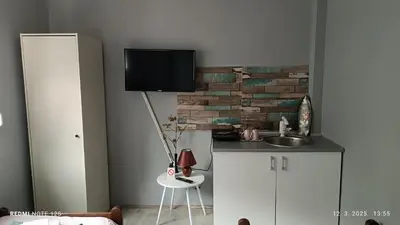 a kitchen with a sink and a tv on a wall at Happy Star in Niš