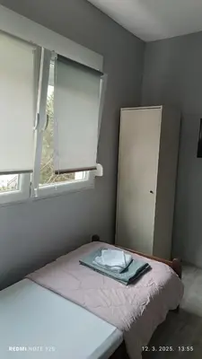 a small bedroom with a bed and a window at Happy Star in Niš