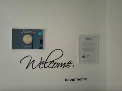 a sign that says welcome to our home on a wall at Happy Star in Niš