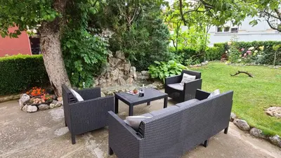 a patio with chairs and a table and a tree at Happy Star in Niš
