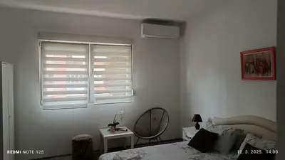 a bedroom with a bed and a window with shutters at Happy Star in Niš