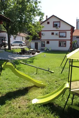 a playground with a slide in a yard at Guest Accommodation Zone in Niška Banja