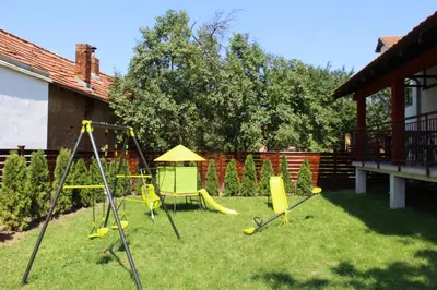 a yard with a playground with yellow swings at Guest Accommodation Zone in Niška Banja
