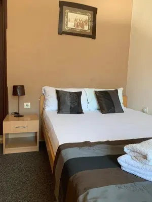 a hotel room with two beds and a night stand at Guest Accommodation Zone in Niška Banja