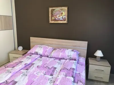 a bedroom with a bed with a purple comforter at Apartman Sofia in Vrnjačka Banja