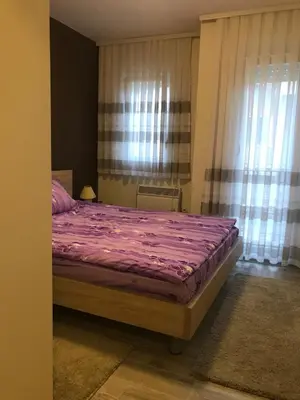 a bedroom with a bed with a purple comforter at Apartman Sofia in Vrnjačka Banja