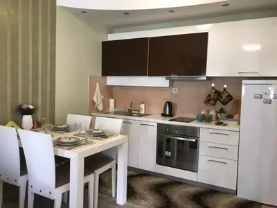 a kitchen with a table and a stove and a refrigerator at Apartman Sofia in Vrnjačka Banja