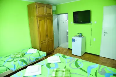 a small room with two beds and a television at PRENOĆIŠTE PILOT in Niš