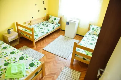 a small room with two beds and a refrigerator at PRENOĆIŠTE PILOT in Niš