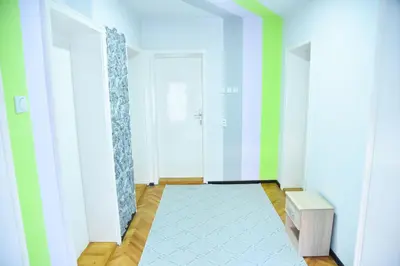 a hallway with green and white walls and a door at PRENOĆIŠTE PILOT in Niš