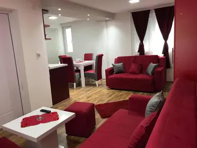 a living room with a red couch and a table at Studio Ivana 1 in Soko Banja