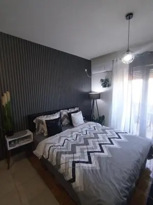 a bedroom with a large bed with a striped wall at Studio ARIES in Vrnjačka Banja