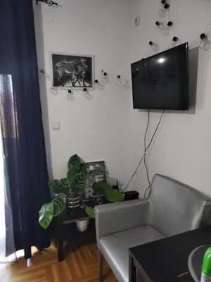a living room with a tv and a couch and a table at Studio ARIES in Vrnjačka Banja