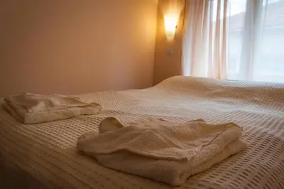 a bed with towels on it with a window at Apartmani 
