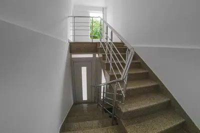 a spiral staircase with a metal railing in a building at Apartmani 