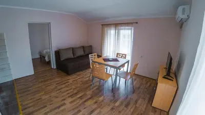 a living room with a table and chairs and a couch at Apartmani 