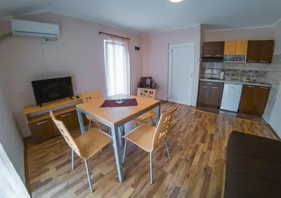 a kitchen and dining room with a table and chairs at Apartmani 
