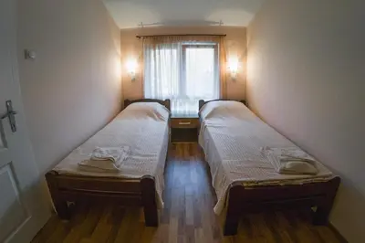 two beds in a small room with a window at Apartmani 