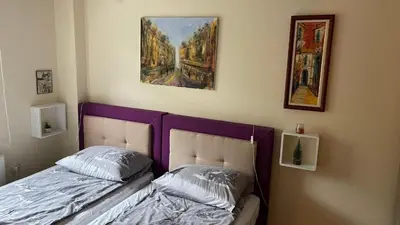 a bedroom with a bed and a painting on the wall at Sunčani Apartman in Brzeće