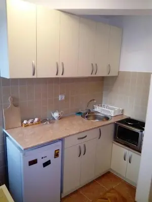 a kitchen with white cabinets and a sink at Apartment Laća in Vrnjačka Banja