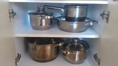 four pots and pans on a shelf in a kitchen at Apartment Laća in Vrnjačka Banja