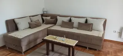 a couch with pillows and a table in a living room at Apartment Laća in Vrnjačka Banja