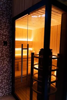 a glass door of a sauna with a table in it at Apartmani Banja SPA in Vrnjačka Banja