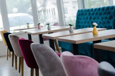 a row of tables and chairs with vases on them at Apartmani Banja SPA in Vrnjačka Banja