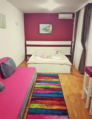 a bedroom with two beds and a colorful rug at Apartmani Banja SPA in Vrnjačka Banja