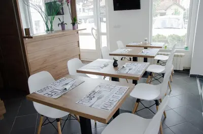 a restaurant with two tables and white chairs at Apartmani Banja SPA in Vrnjačka Banja