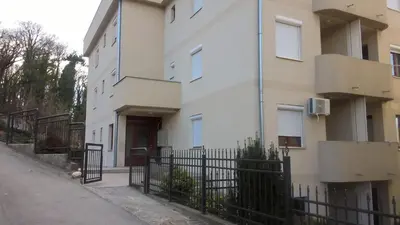 an apartment building with a fence in front of it at Nidza Vranjanac in Vrnjačka Banja