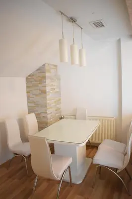 a dining room with a white table and chairs at Apartments Holiday in Vranje