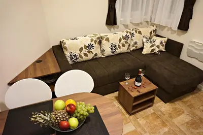 a living room with a couch and a table with a bowl of fruit at Vila Plan 404 in Kopaonik