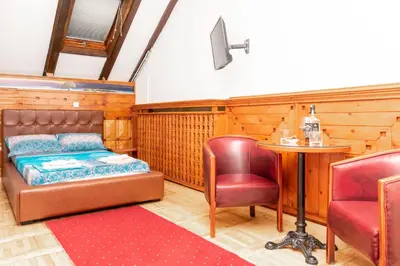 a bedroom with a bed and a table and chairs at Fortezza rooms in Niš