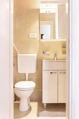 a bathroom with a toilet and a sink and a mirror at Fortezza rooms in Niš