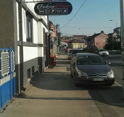a car parked on the side of a street at Fortezza rooms in Niš
