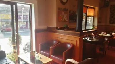 a restaurant with a bar with chairs and a window at Fortezza rooms in Niš
